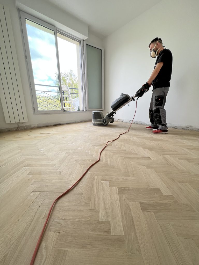 ouvrier qui ponce du parquet